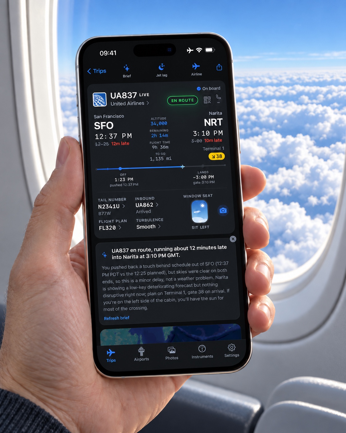 A hand holding an iPhone showing the Jet Window flight brief beside an airplane window above sunlit clouds