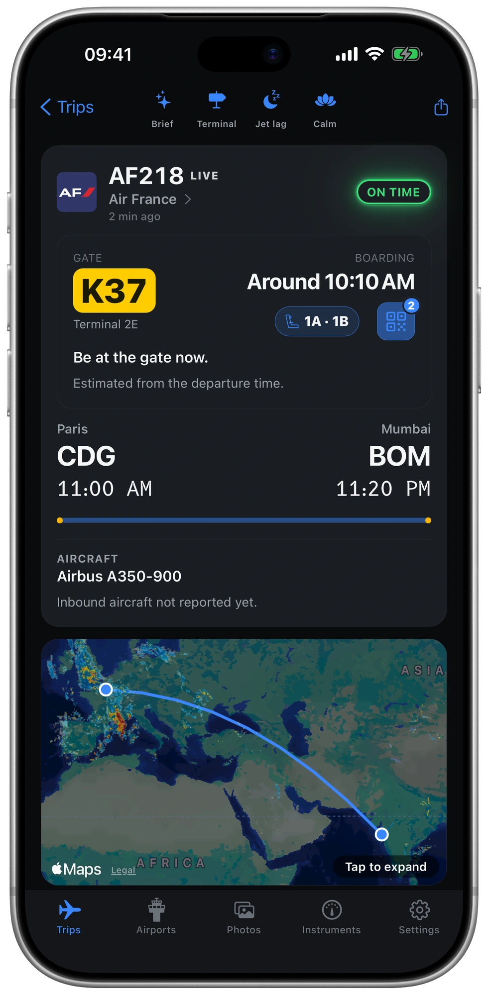 The same flight screen in the night theme: gate K37, seats 1A and 1B, and the boarding passes.